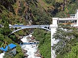 09 Friendship Bridge Between Kodari Nepal And Zhangmu Tibet After Crossing The Friendship Bridge From Kodari After passing through China Customs and Immigration, I walk up the road to our awaiting Landcruiser. I look back to see the thundering Bhote Kosi (River From Tibet) flowing under the Friendship Bridge.